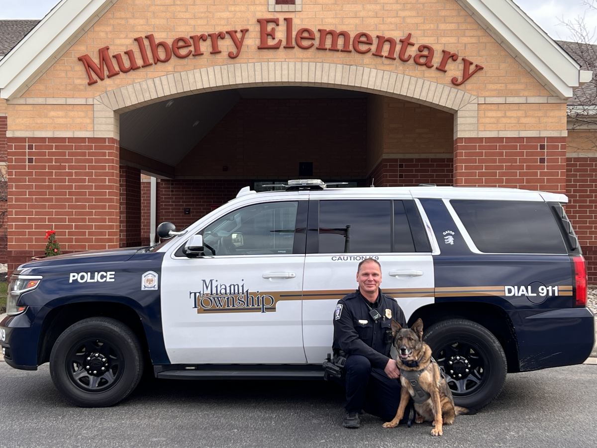 Officer Craig Heintzelman and his K9 in front of Mulberry Elementary school